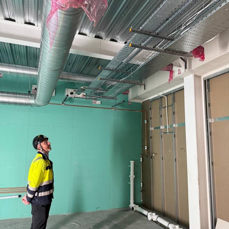 Cable tray and basket suspended on Zip-Strut above a site visitor inspecting the install